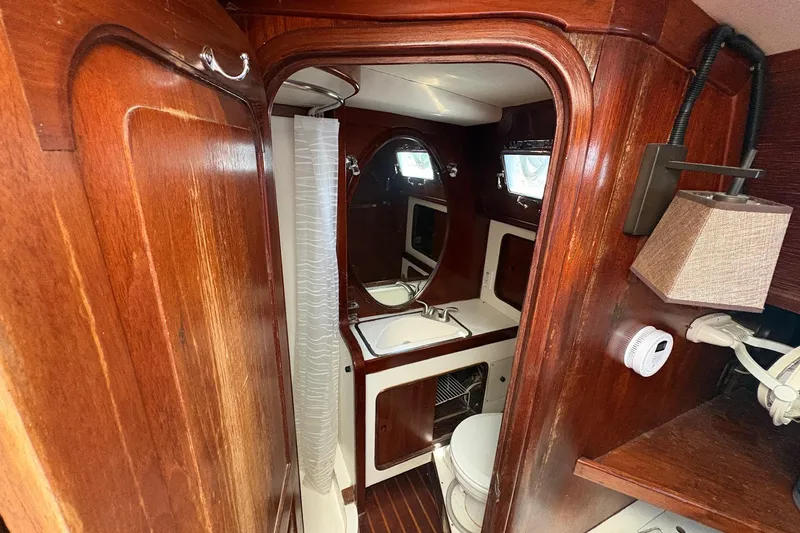 Slide: The Image of Interior of 1980 Gulfstar 50 CC Ketch, featuring wooden cabinetry and compact bathroom amenities. - 33