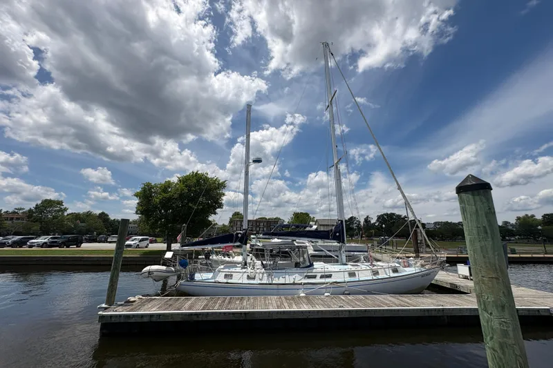 The Image of 1980 Gulfstar 50 CC Ketch docked under a partly cloudy sky. - 1
