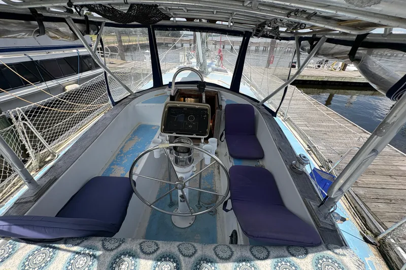 Slide: The Image of Cockpit of 1980 Gulfstar 50 CC Ketch with steering wheel and seating, docked at marina. - 13