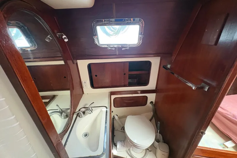 Slide: The Image of 1980 Gulfstar 50 CC Ketch bathroom with sink, toilet, and wooden cabinetry. - 39