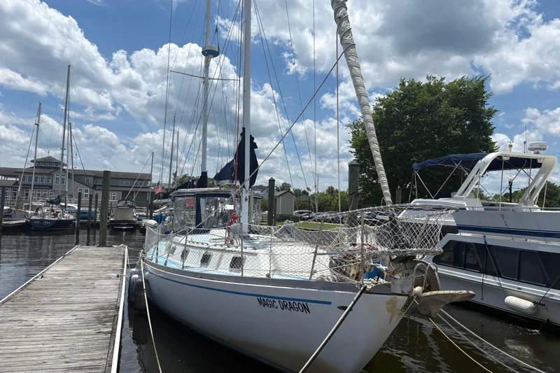 Slide: The Image of 1980 Gulfstar 50 CC Ketch sailboat docked at marina under a partly cloudy sky. - 6