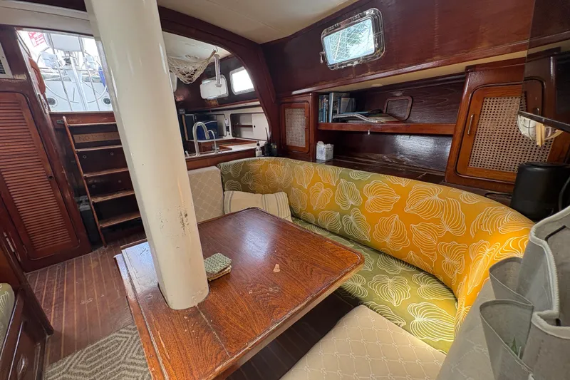 Slide: The Image of Interior of 1980 Gulfstar 50 CC Ketch with wooden table, colorful seating, and nautical decor. - 19