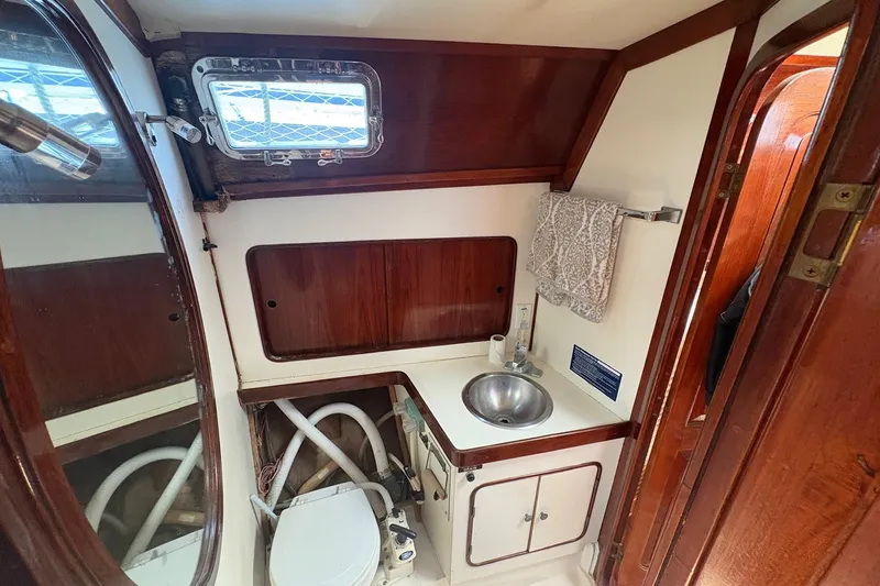 Slide: The Image of Interior of 1980 Gulfstar 50 CC Ketch bathroom with sink, toilet, and wooden cabinetry. - 45