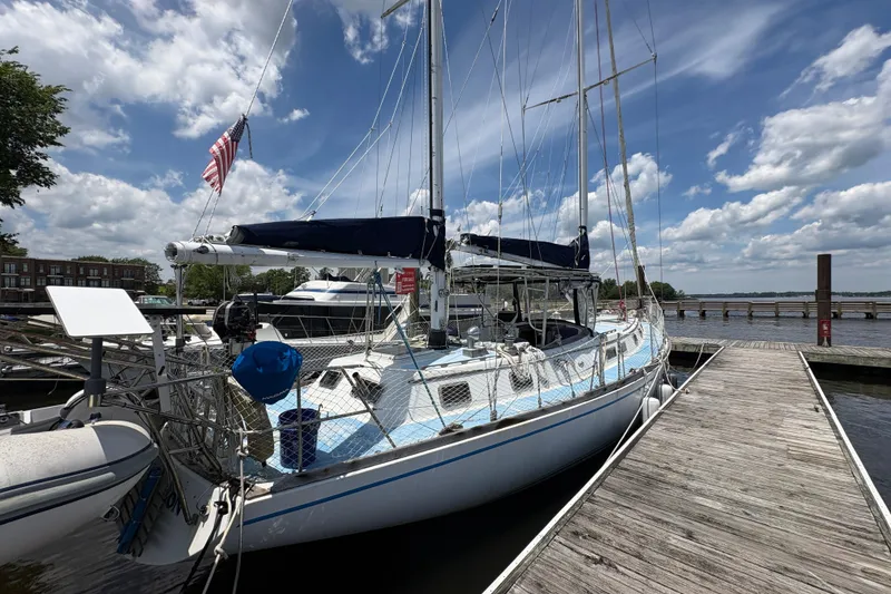 Slide: The Image of 1980 Gulfstar 50 CC Ketch sailboat docked under a partly cloudy sky. - 5