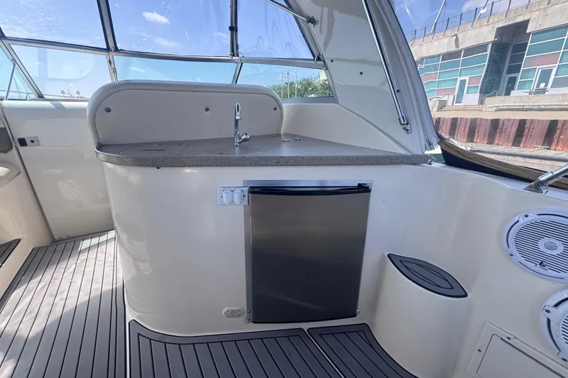 Slide: The Image of 2003 Rinker Fiesta Vee 312 boat interior with kitchenette and mini fridge. - 7