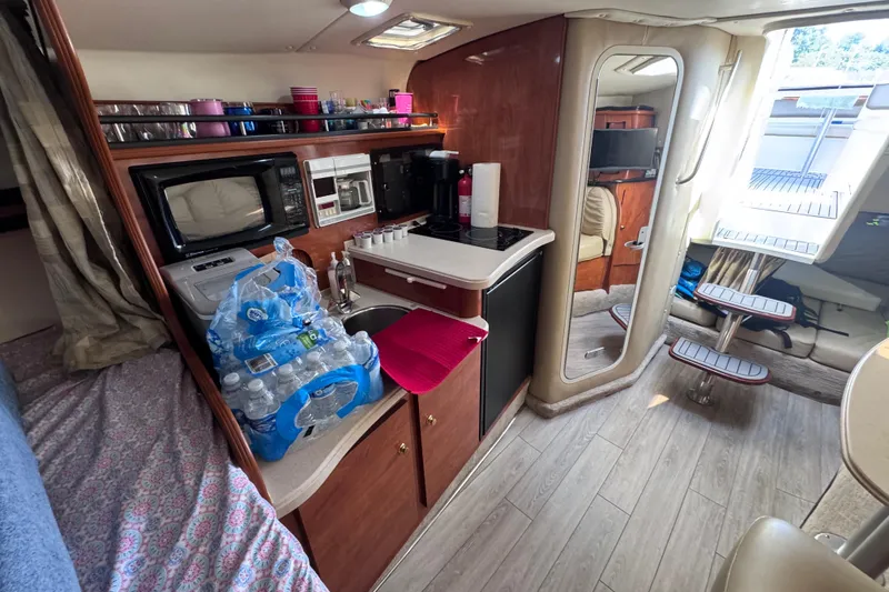 Slide: The Image of 2003 Rinker Fiesta Vee 312 cabin interior with kitchenette, microwave, and seating area. - 19