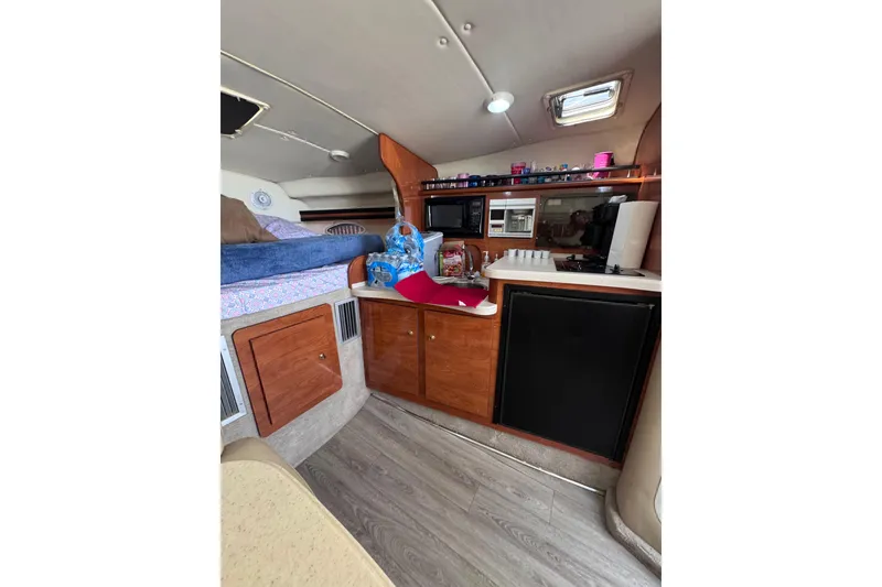 Slide: The Image of Interior of 2003 Rinker Fiesta Vee 312 boat with kitchenette and sleeping area. - 26