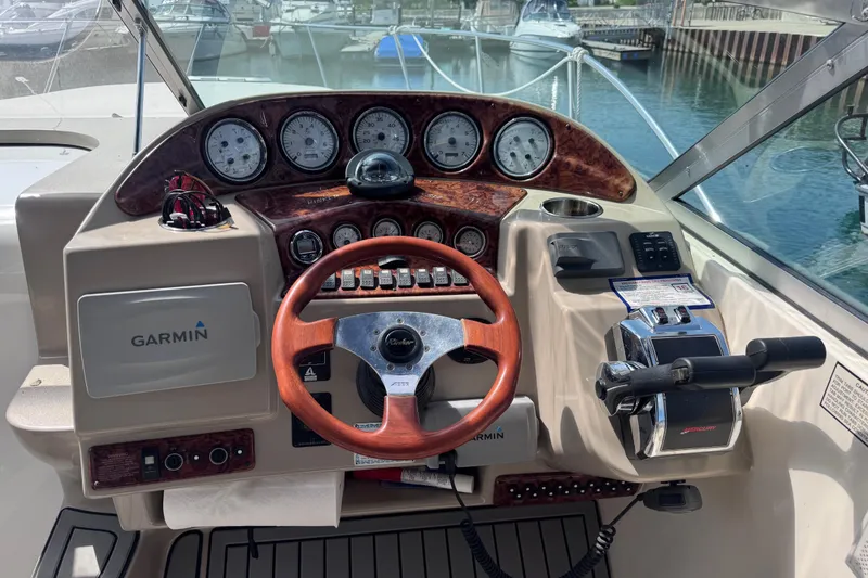 Slide: The Image of Cockpit of 2003 Rinker Fiesta Vee 312 with Garmin navigation and wood-accented steering wheel. - 8