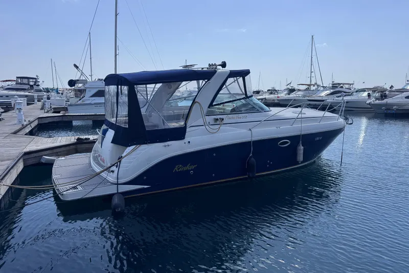 Slide: The Image of 2003 Rinker Fiesta Vee 312 boat docked at marina, calm water, clear sky. - 1