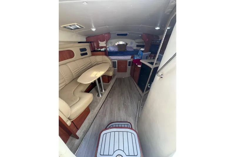Slide: The Image of 2003 Rinker Fiesta Vee 312 cabin interior with seating, table, and kitchenette. - 15