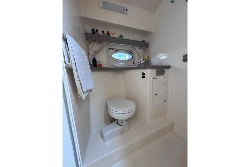 Slide: The Image of Bathroom interior of 2003 Rinker Fiesta Vee 312 boat, featuring toilet and storage. - 24