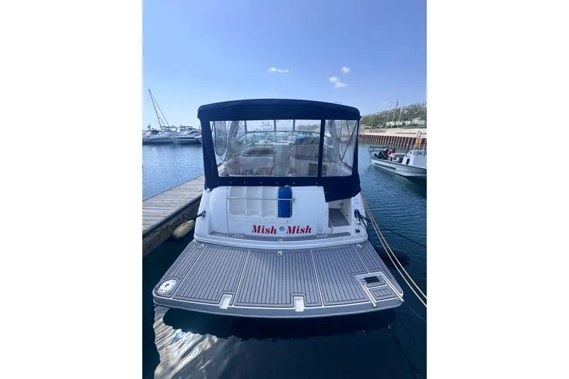 Slide: The Image of 2003 Rinker Fiesta Vee 312 boat docked at marina, rear view with canopy. - 2
