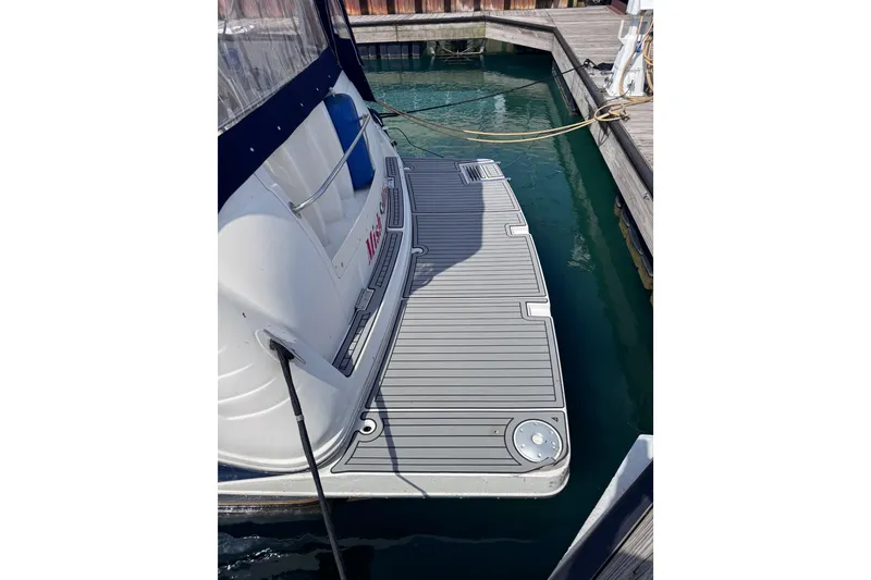 Slide: The Image of 2003 Rinker Fiesta Vee 312 boat docked, featuring a spacious swim platform. - 3