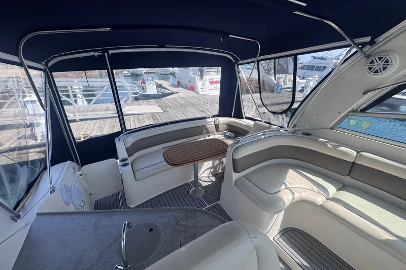 Slide: The Image of 2003 Rinker Fiesta Vee 312 boat interior with seating and table, docked at marina. - 12