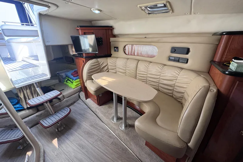 Slide: The Image of Interior of 2003 Rinker Fiesta Vee 312 yacht with beige seating and compact dining area. - 21