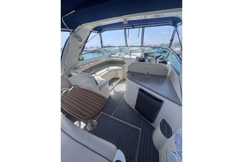 Slide: The Image of 2003 Rinker Fiesta Vee 312 boat interior with seating, table, and kitchenette. - 5