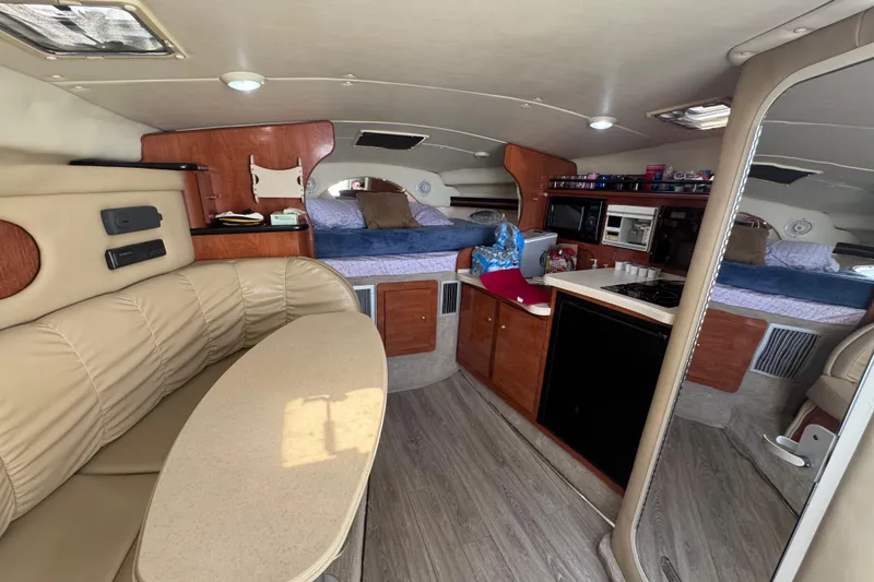 Slide: The Image of Interior of a 2003 Rinker Fiesta Vee 312 boat with cozy seating and kitchenette. - 16