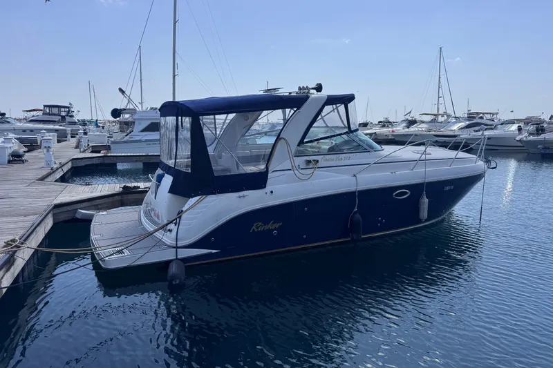 The Image of 2003 Rinker Fiesta Vee 312 boat docked at marina, surrounded by other vessels. - 0