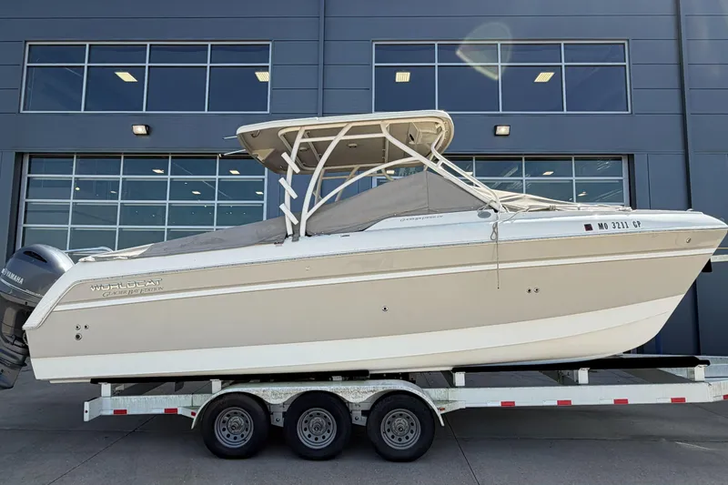 Slide: The Image of 2016 World Cat Glacier Bay Edition 2740 Dual Console boat on trailer, parked outside a building. - 1