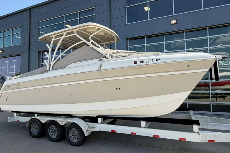 Slide: The Image of 2016 World Cat Glacier Bay Edition 2740 Dual Console boat on trailer, parked outside a building. - 2