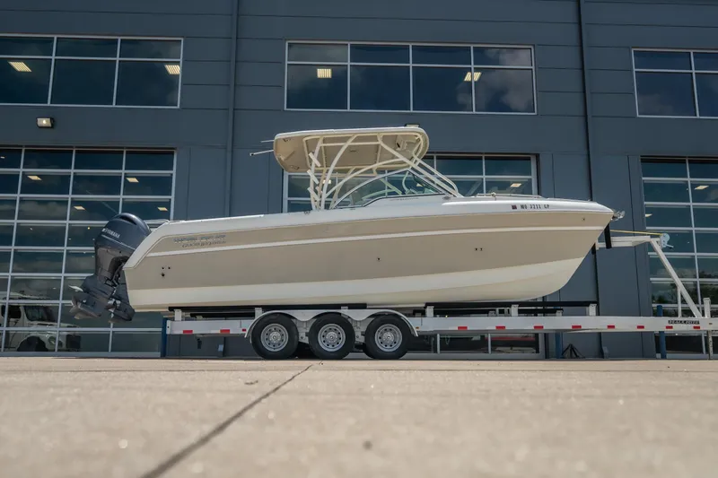 The Image of 2016 World Cat Glacier Bay Edition 2740 Dual Console boat on trailer, parked outside. - 0