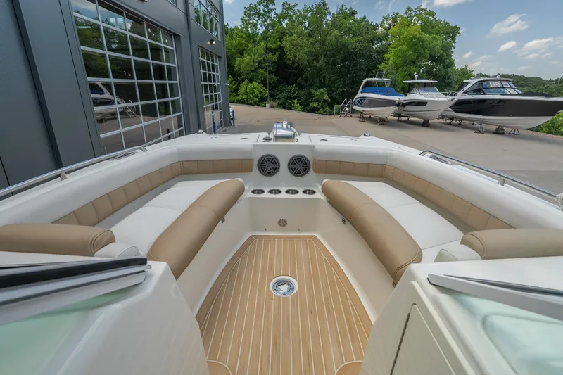 Slide: The Image of 2016 World Cat Glacier Bay Edition 2740 Dual Console boat interior with beige seating and wood flooring. - 12