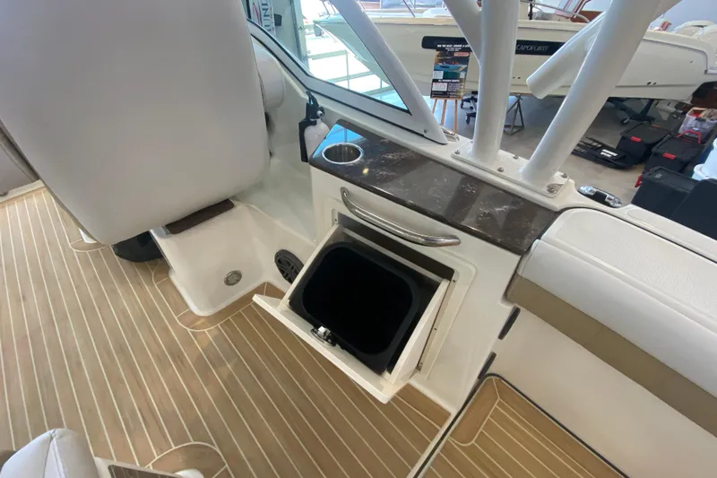 Slide: The Image of 2016 World Cat Glacier Bay Edition 2740 Dual Console interior with storage compartment and cup holder. - 34