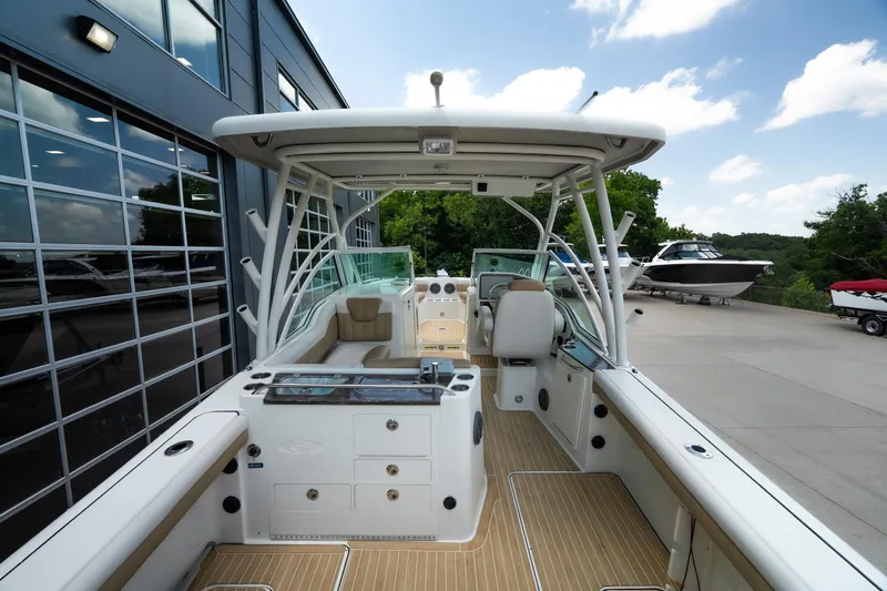 Slide: The Image of 2016 World Cat Glacier Bay Edition 2740 Dual Console boat, docked outdoors, showcasing spacious interior and seating. - 9