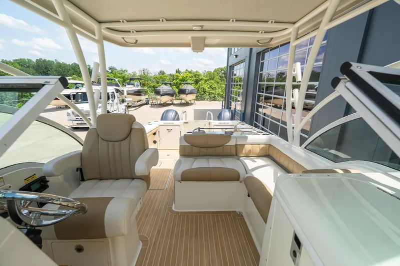 Slide: The Image of 2016 World Cat Glacier Bay Edition 2740 Dual Console boat interior with beige seating and helm. - 16