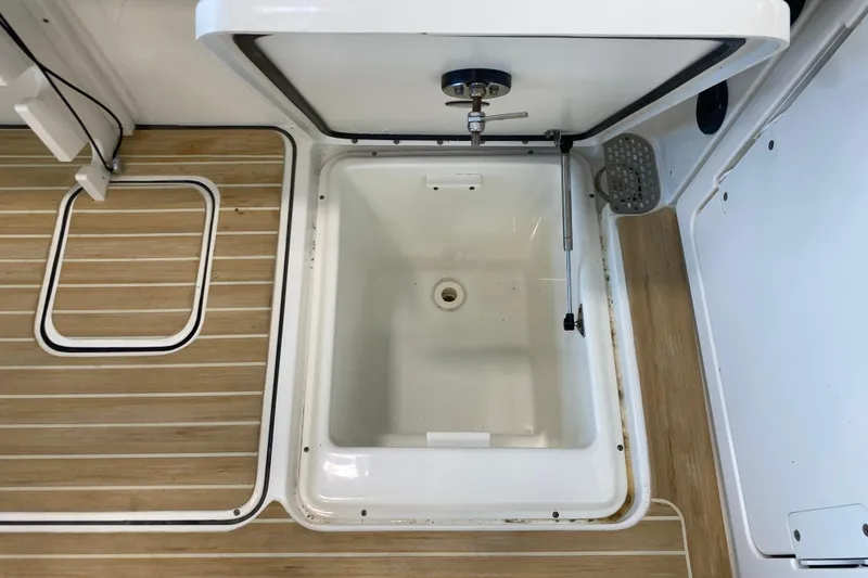 Slide: The Image of 2016 World Cat Glacier Bay Edition 2740 boat storage compartment with wooden deck flooring. - 31