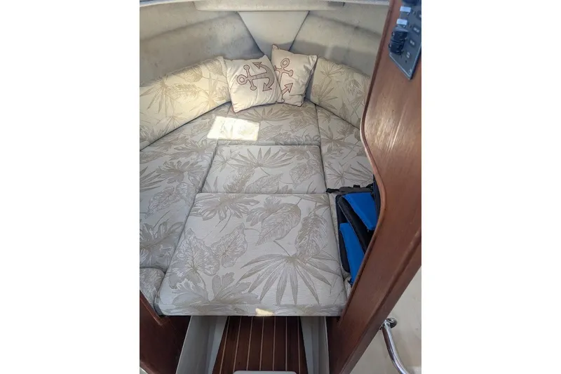 Slide: The Image of 2008 Ranger 2510 Bay Ranger cabin interior with floral cushions and anchor-themed pillows. - 40