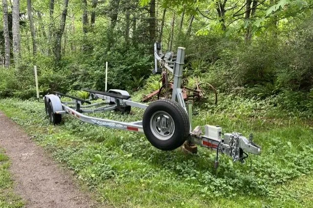 Slide: The Image of 2008 Ranger 2510 Bay Ranger boat trailer in a lush, wooded area. - 11