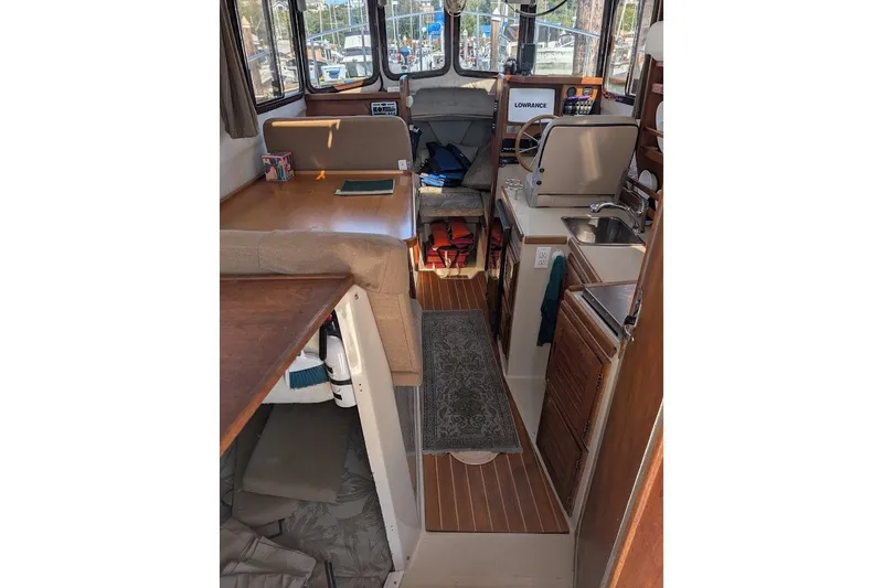 Slide: The Image of Interior of 2008 Ranger 2510 Bay Ranger boat with seating, kitchenette, and navigation equipment. - 23