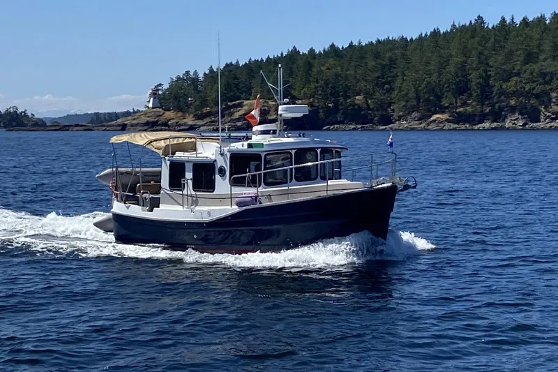 Slide: The Image of 2008 Ranger 2510 Bay Ranger cruising on a scenic lake with forested shoreline. - 2