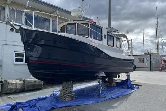 Slide: The Image of 2008 Ranger 2510 Bay Ranger boat on dry dock, blue hull, marina background. - 6