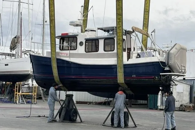 Slide: The Image of 2008 Ranger 2510 Bay Ranger boat being lifted for maintenance at a marina. - 3