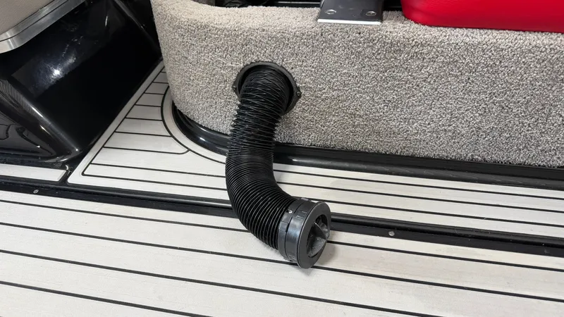 Slide: The Image of A black hose is attached to the side of a boat, surrounded by carpeted flooring. - 31