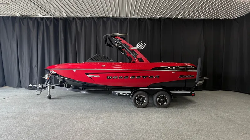 Slide: The Image of A red 2015 Malibu Wakesetter 23 LSV boat on a trailer in a showroom. - 0