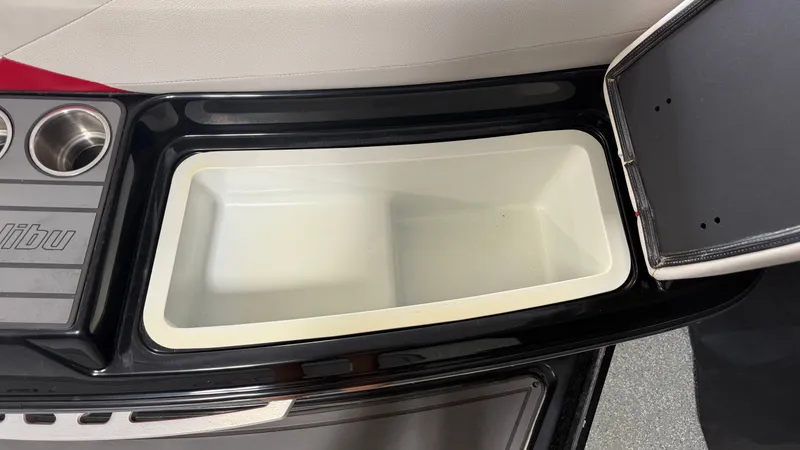Slide: The Image of An open storage compartment on a Malibu Wakesetter 23 LSV boat, with cup holders beside it. - 17