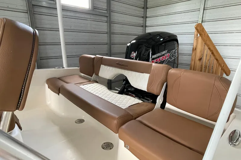 Slide: The Image of 2024 Pioneer 180 Islander boat interior with brown seating and Mercury Pro XS engine. - 9