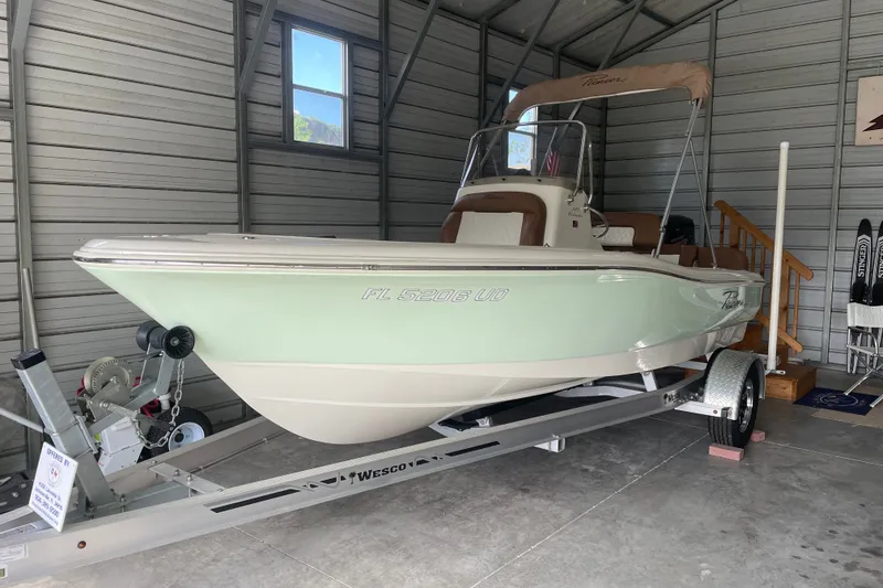 Slide: The Image of 2024 Pioneer 180 Islander boat on trailer in a garage setting. - 24