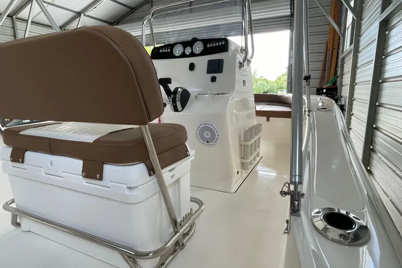 Slide: The Image of 2024 Pioneer 180 Islander boat interior with seating and control panel in a covered storage area. - 18