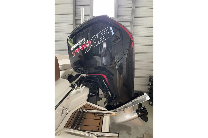 Slide: The Image of 2024 Pioneer 180 Islander with Mercury Pro XS outboard motor in a garage setting. - 5