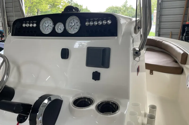 Slide: The Image of 2024 Pioneer 180 Islander boat dashboard with gauges and controls in a garage setting. - 19