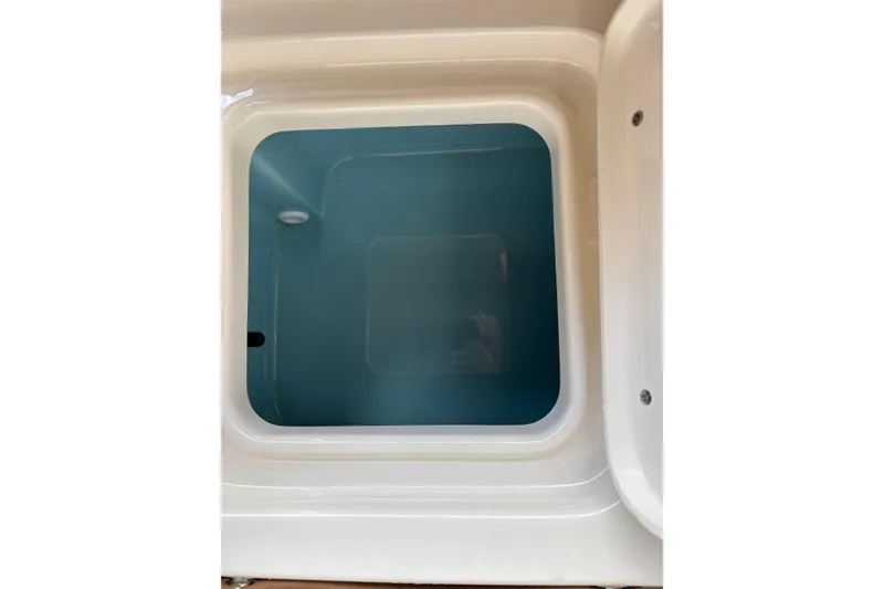Slide: The Image of Livewell compartment of 2024 Pioneer 180 Islander boat, featuring a clean, white interior. - 23