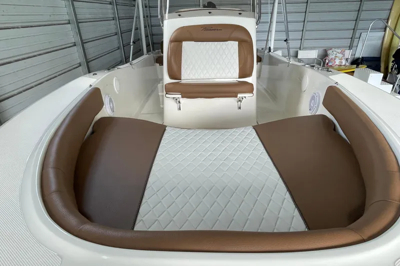 Slide: The Image of 2024 Pioneer 180 Islander boat interior with brown and white cushioned seating. - 16
