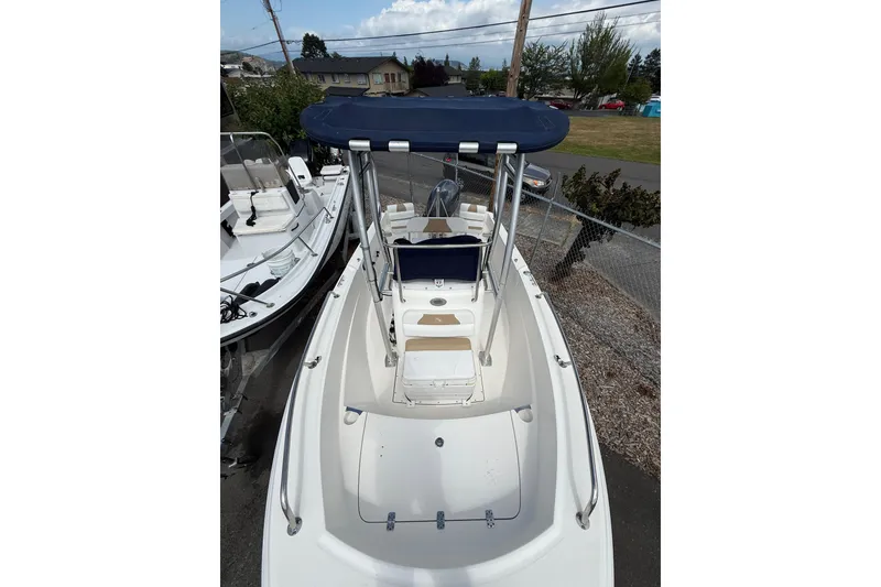 Slide: The Image of 2015 Edgewater 170CC boat with blue canopy, parked outdoors. - 14