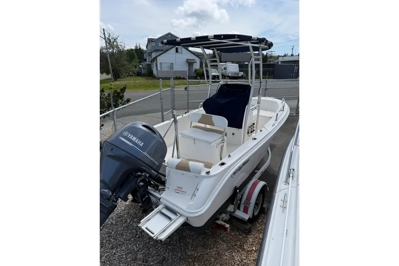 Slide: The Image of 2015 Edgewater 170CC boat with Yamaha outboard motor, parked outdoors. - 11
