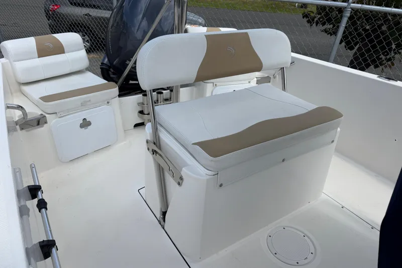 Slide: The Image of 2015 Edgewater 170CC boat interior with white and beige seating, showcasing storage compartments. - 12