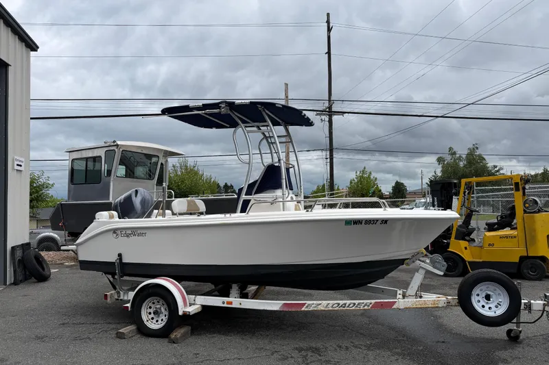 Slide: The Image of 2015 Edgewater 170CC boat on trailer, parked outdoors under cloudy sky. - 5